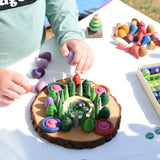 Child making a mandala on a large log slice from the Magic Wood Eco Blocks Big Box 70 piece set.