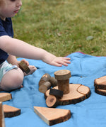 Child playing with pieces from the Magic Wood Eco Blocks Big Box 70 piece set stacking them on top of each other.