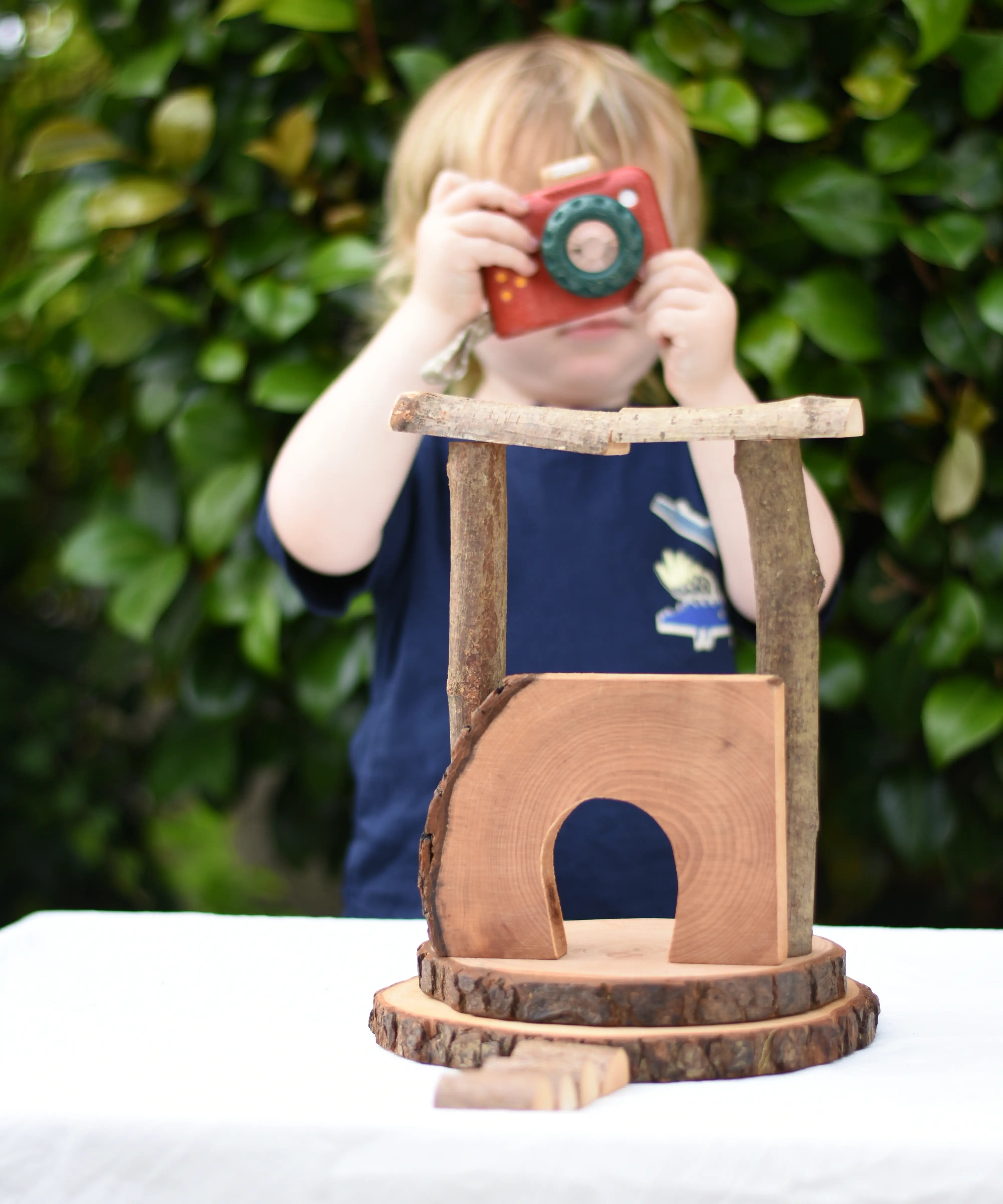 Small build created using the Magic Wood Eco Blocks Big Box 70 piece set. Child in background with a PlanToys camera.