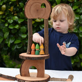 Child Placing tomten on a build created using the Magic Wood Eco Blocks Big Box 70 piece set.
