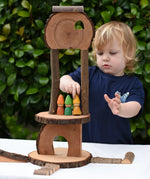 Child Placing tomten on a build created using the Magic Wood Eco Blocks Big Box 70 piece set.
