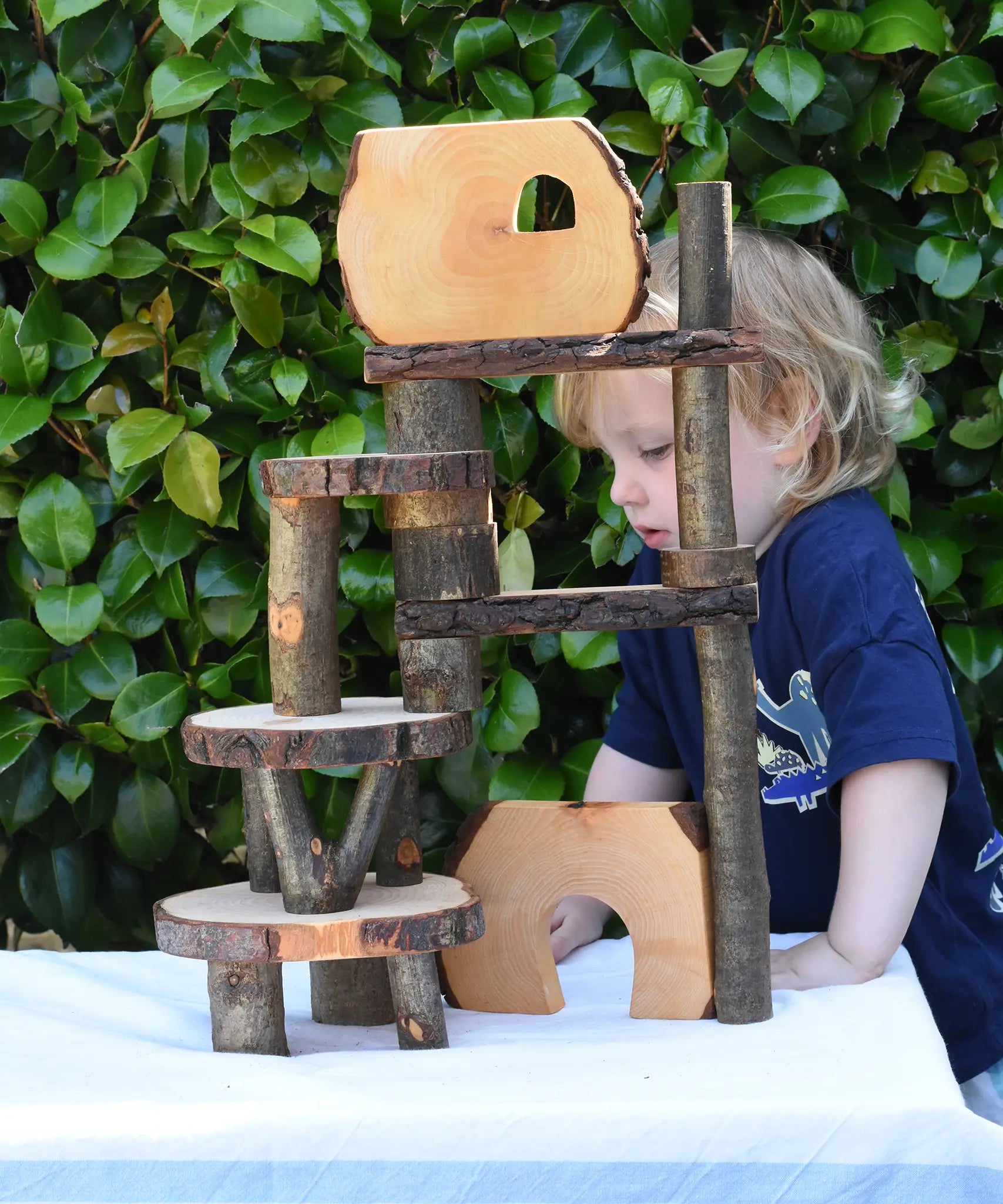 Child standing behind a build created using the Magic Wood Eco Blocks in a 22 piece set