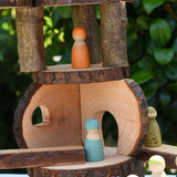 Close up of Grimm;s friends peg dolls placed on a structure created using pieces from the  Magic Wood oiled ecoBlocks 36 piece set.