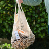 Child holding the  Magic Wood wooden oiled ecoBlocks 36 piece set in it's net storage bag.