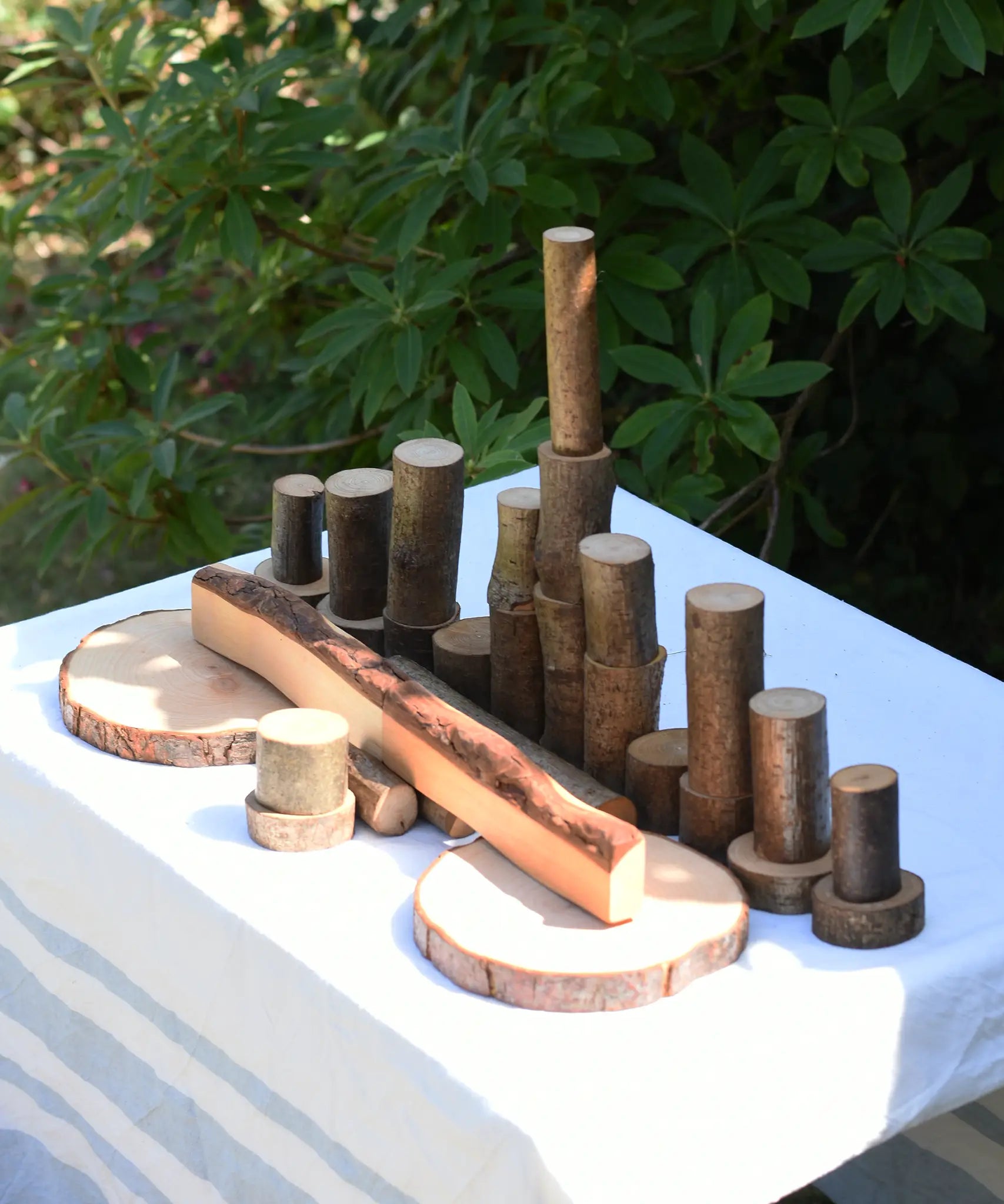  Magic Wood oiled ecoBlocks 36 piece set, with pieces lines up on a table outdoors.