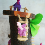 Magic Wood pose-able felt elves with the log cabin. one is stood at the top