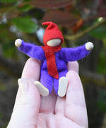 A purple Magic Wood Elf shown in a persons hand to show scale. 