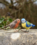 Two felted birds, a robin and a blue tit. Both have been created using craft kits by the Makerss.
