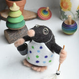 A felted mole figure wearing a spotty apron holding a bucket and a mop. The figure has been created using The Makerss Small Busy Mr Mole Needle Felt Kit.