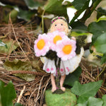 A Daisy flower fairy placed on an ivy covered tree branch. The fairy has been made using The Makerss Official Flower Fairies Daisy Fairy Needle Felt Kit.