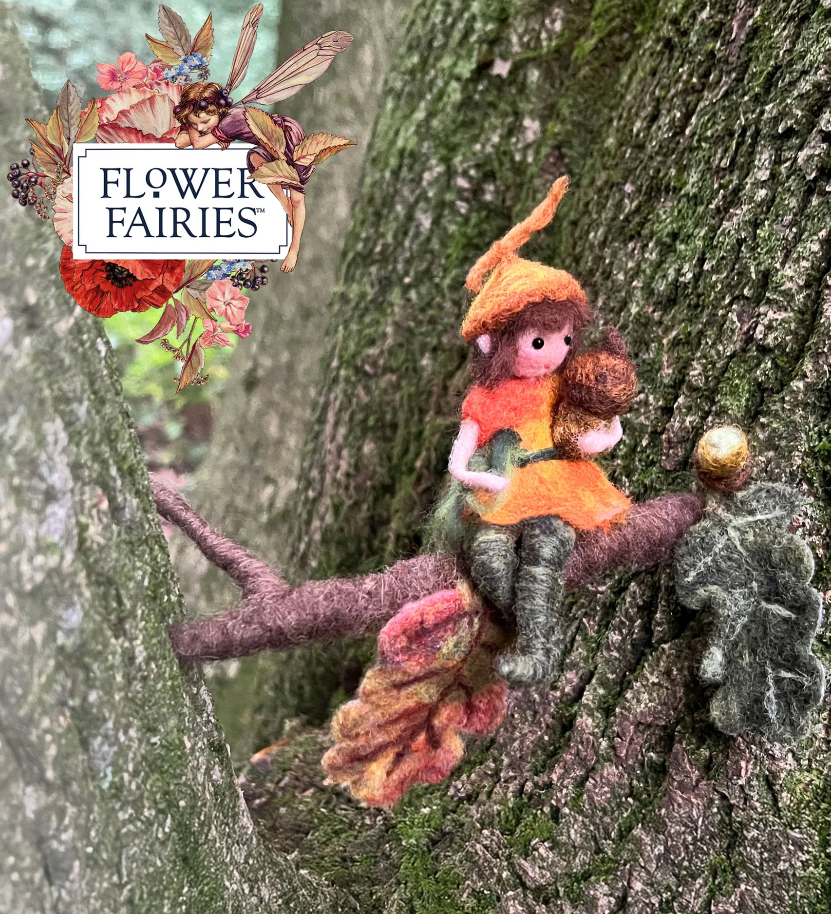 The Makerss Official Flower Fairies™️ acorn fairy needle felt kit finished product placed on a tree. 
