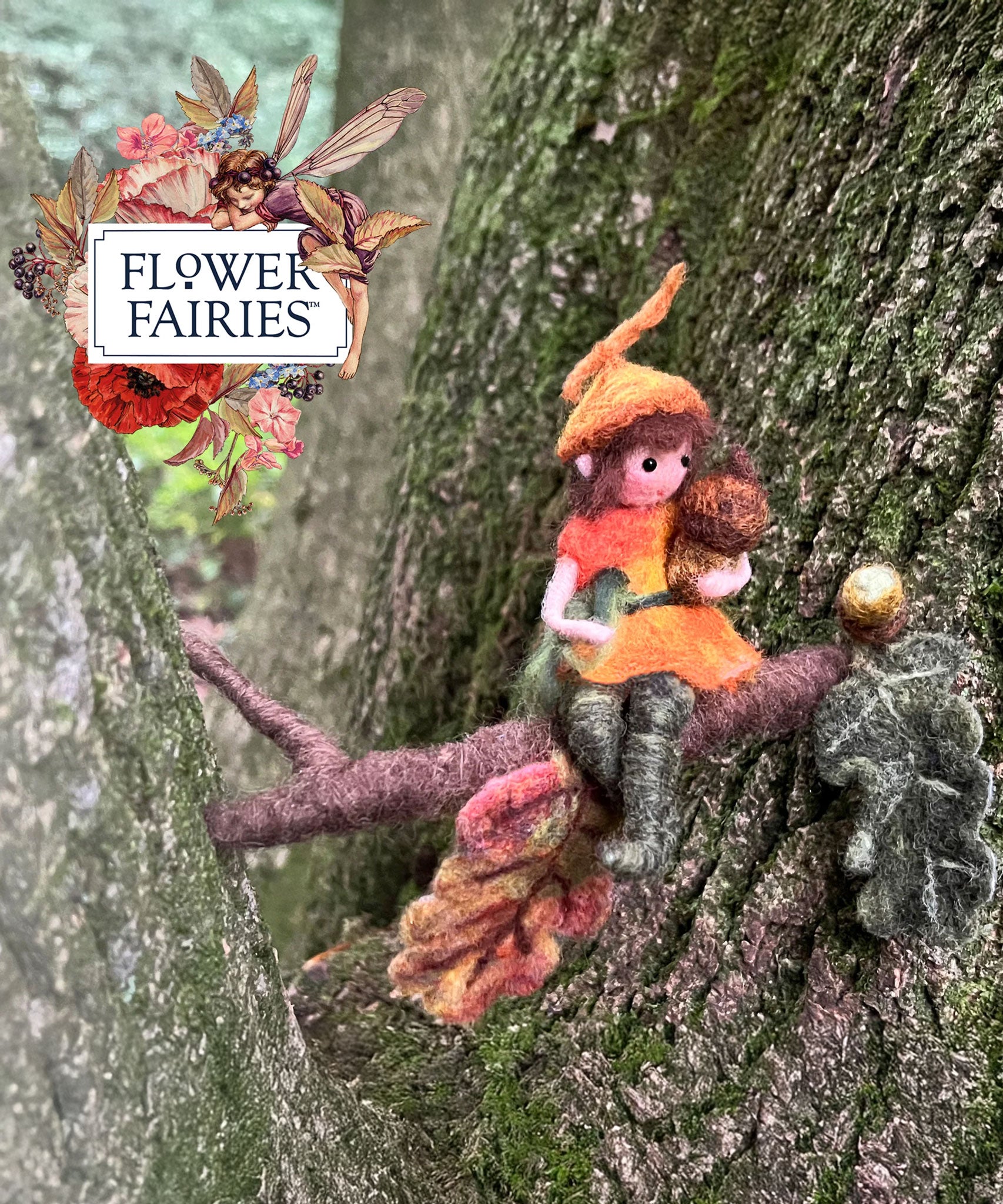 The Makerss Official Flower Fairies™️ acorn fairy needle felt kit finished product placed on a tree. 