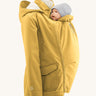 Mamalila Allweather Cosy Allrounder Babywearing Jacket in a Mustard yellow colour. The jacket is shown with the babywearing insert and a doll.