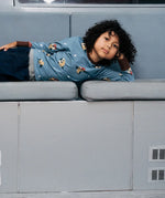 Child wearing the Maxomorra GOTS organic cotton long sleeve top in blue with a cute repeating owl print and brown neck line and cuffs.