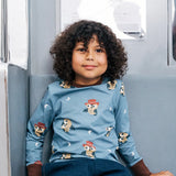 Child wearing the Maxomorra GOTS organic cotton long sleeve top in blue with a cute repeating owl print and brown neck line and cuffs.