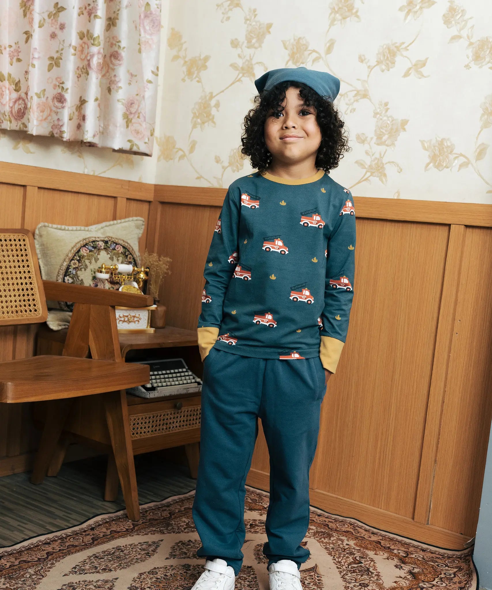 Child wearing the Maxomorra kids baggy sweat pants in navy, features a drawstring cord around the waist and side pockets with fire truck print long sleeved top.