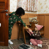 Two children wearing Maxomorra organic cotton clothing. one wearing green fox print long sleeve top one wearing the brown apple print top with ink trousers. 