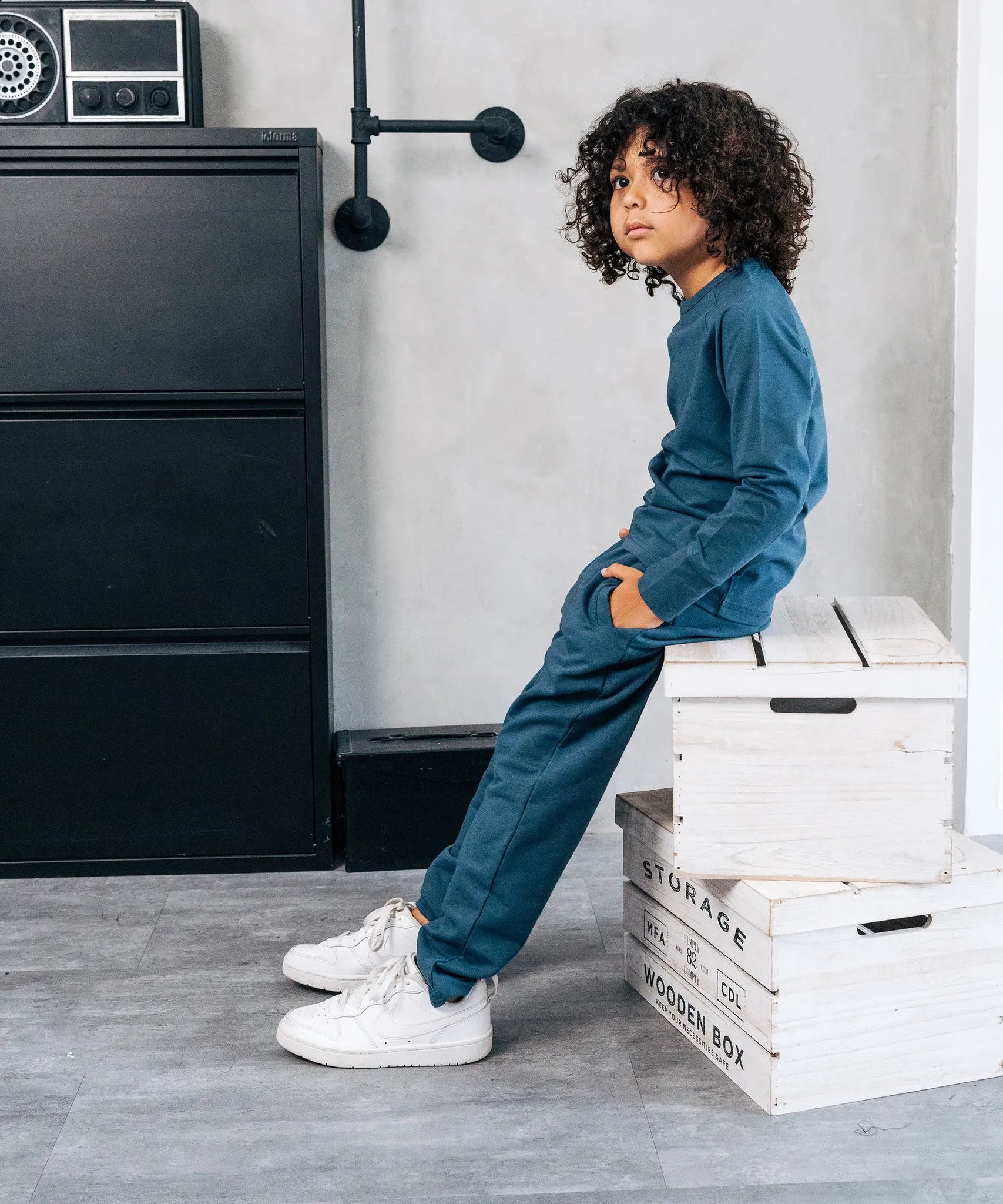 Child wearing the Maxomorra kids baggy sweat pants in blue, features a drawstring cord around the waist and side pockets with matching long sleeved top.