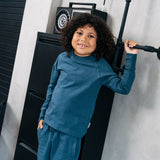 Child wearing the Maxomorra organic cotton kids baggy sweat pants in navy, features a drawstring cord around the waist and side pockets with matching long sleeved top.
