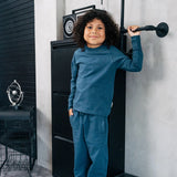 Child wearing the Maxomorra organic cotton kids baggy sweat pants in blue, features a drawstring cord around the waist and side pockets with matching long sleeved top.