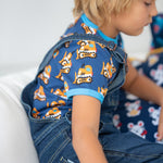 Close up of boy wearing the Maxomorra bulldozer short sleeve top under the navy denim dungarees