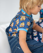 Close up of boy wearing the Maxomorra bulldozer short sleeve top under the navy denim dungarees