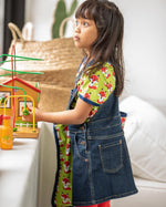 Girl stood up wearing the Maxomorra denim pinafore dress over the short sleeve organic cotton fox top