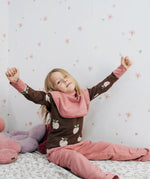 Child wearing the Maxomorra GOTS organic cotton long sleeve top in brown with a cute repeating pink apple print and pale pink neck line and cuffs with pink trousers.
