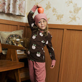 Child wearing the Maxomorra GOTS organic cotton long sleeve top in brown with a cute repeating pink apple print and pale pink neck line and cuffs with pink trousers and beanie style hat.