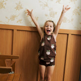 Girl wearing the Maxomorra's  GOTS organic cotton kids tank top in brown with a cute repeating pink apple print with matching trim with matching printpants.