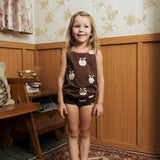 Girl wearing the Maxomorra's  GOTS organic cotton kids tank top in brown with a cute repeating pink apple print with matching trim with matching pants.