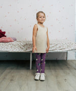 Girl wearing the Maxomorra kids GOTS organic cotton leggings in purple with a repeating cute hedgehog print and elasticated waist band with a cream vest top.