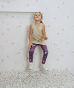Girl wearing the Maxomorra kids GOTS organic cotton leggings in purple with a repeating cute hedgehog print and elasticated waist band with a cream vest top.