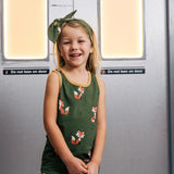 Child wearing the Maxomorra kids organic cotton green fox print vest with yellow trousers on a train.