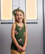 Child wearing the Maxomorra kids organic cotton green fox print vest with yellow trousers on a train.