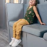 Child wearing the Maxomorra kids organic cotton green fox print vest with yellow trousers sitting on a train.