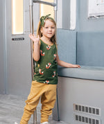 Child wearing the Maxomorra kids organic cotton green fox print vest with yellow trousers standing on a train.