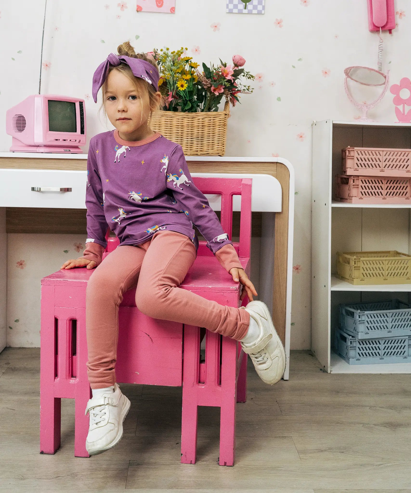 Child wearing the Maxomorra kids unicorns organic cotton long sleeve top with leggings. Purple top with  repeat unicorn print and light pink arm cuffs and binding on the neck. 