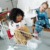 Child sitting in a trolley wearing the Maxomorra organic cotton long sleeved viking print top with mustard yellow trousers. 