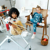 Child sitting in a trolley wearing the Maxomorra organic cotton long sleeved viking print top with mustard yellow trousers. 