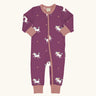 Maxomorra organic cotton zipped babygrow with unicorns. Purple background with repeat print featuring unicorns with multi coloured manes and yellow stars with pink arm cuffs, binding on the neck and zip.