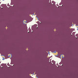 Maxomorra unicorns print on organic cotton. Purple background with all over repeat print featuring unicorns with multicoloured manes and yellow sparkles. 