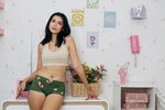 Woman wearing the Maxomorra GOTS organic cotton women's brief hipster pants in green with a repeating cartoon fox print with cream comfort bra top.