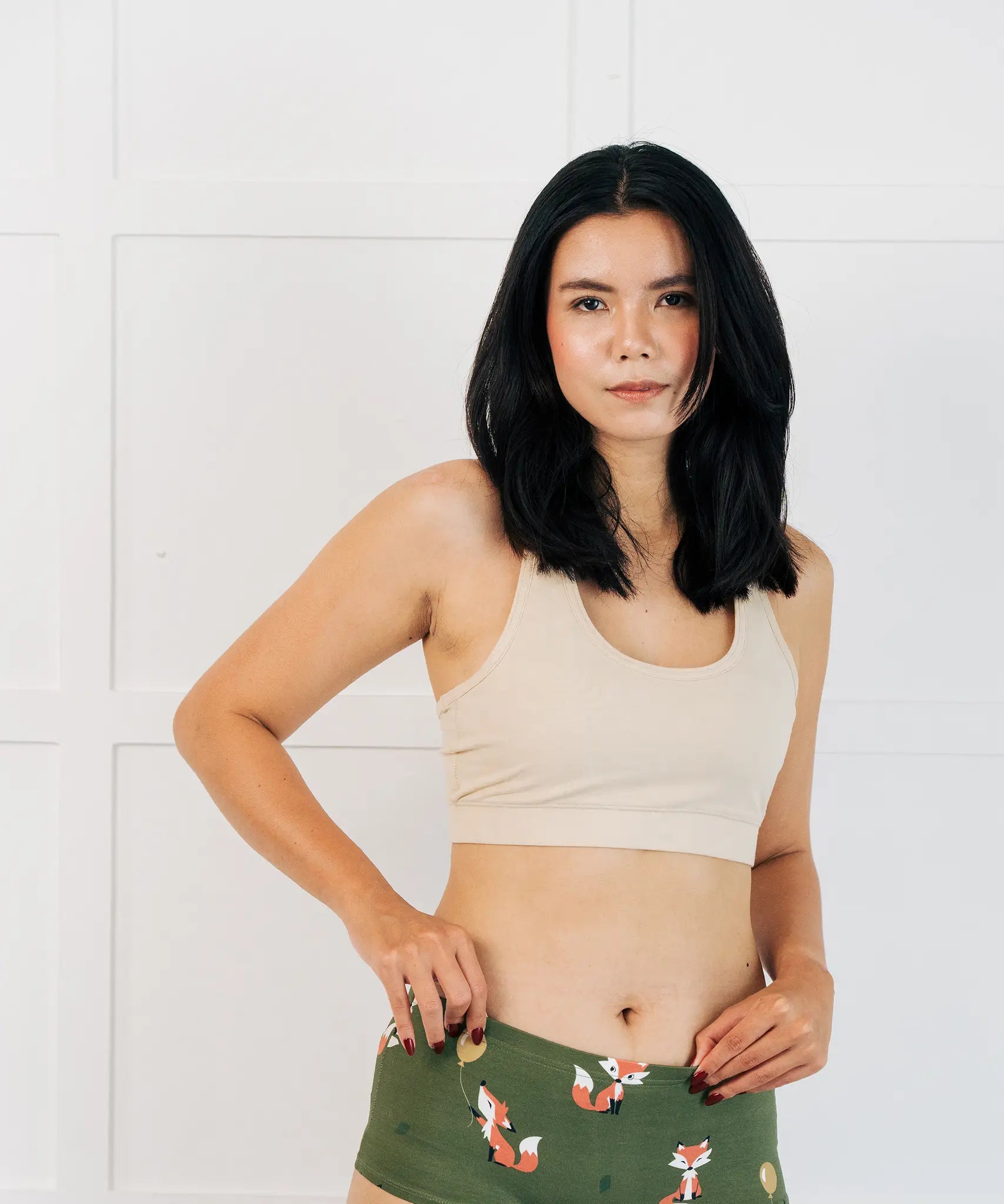 Woman wearing the Maxomorra GOTS organic cotton women's brief hipster pants in green with a repeating cartoon fox print with cream comfort bra top.