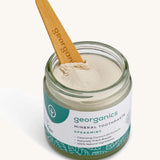 A opened jar of the Georganics spearmint mineral toothpaste on a cream background.