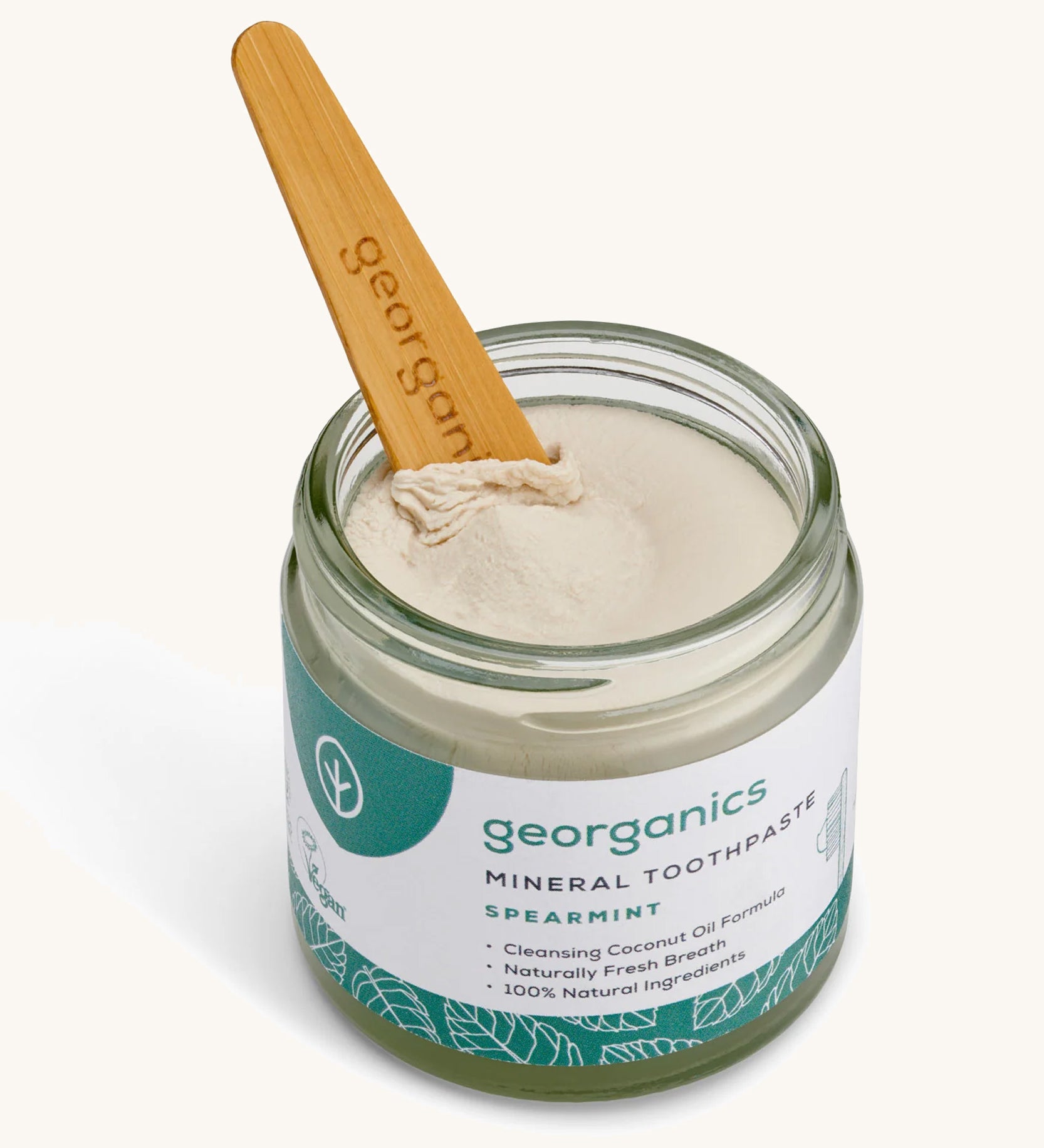 A opened jar of the Georganics spearmint mineral toothpaste on a cream background.