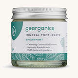 A jar of the Georganics spearmint mineral toothpaste on a cream background.