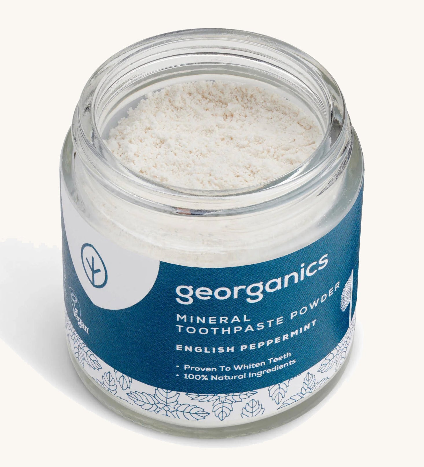  A  opened jar of the peppermint  Georganics toothpaste powder on a cream background