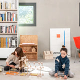 Children building a house made from various wooden poles and blocks out of the Trigonos mini large construction set 