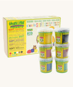 ÖkoNORM nawaro classic soft modelling clay set in natural colours. The packaging is a yellow and brown box with eco-friendly branding, featuring an illustration of an owl and colourful clay balls. Six small transparent tubs with green labels are stacked in front, each containing a different colour of soft, natural modelling clay, including yellow, black, red, brown, blue, and green. The product is labelled as non-toxic, biodegradable, and made from natural ingredients.